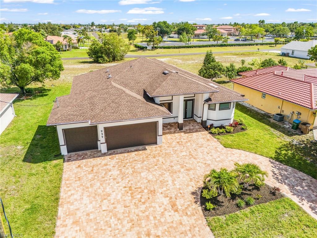 Contemporary home featuring a dual garage, paver driveway, and landscaped entry