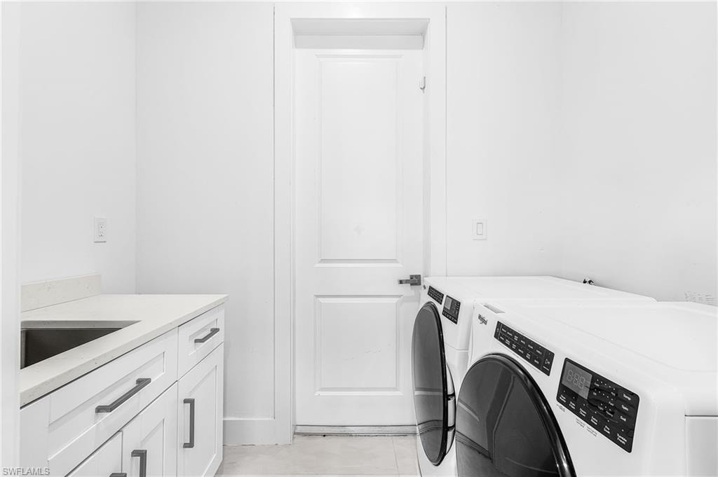 Utility room featuring white cabinetry, a light-toned countertop, and a stainless steel sink