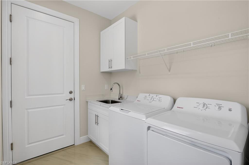 Spacious INTERIOR LAUNDRY ROOM includes additional cabinetry and utility sink for added convenience.