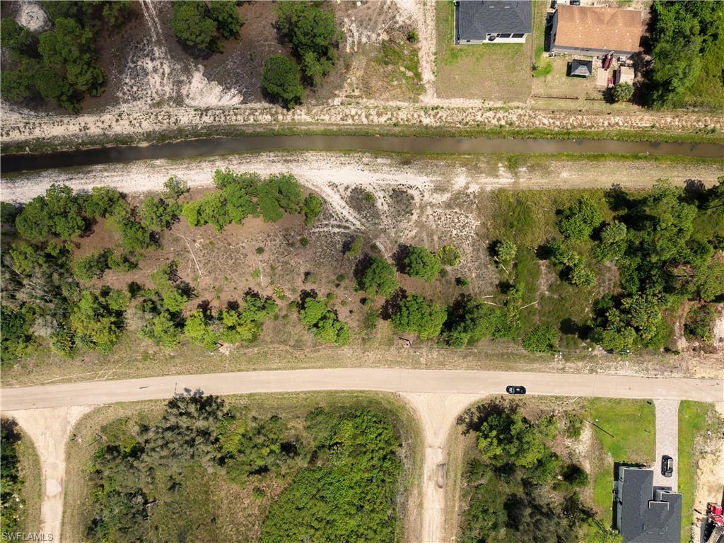 Expansive undeveloped lot featuring mature trees and a natural water canal