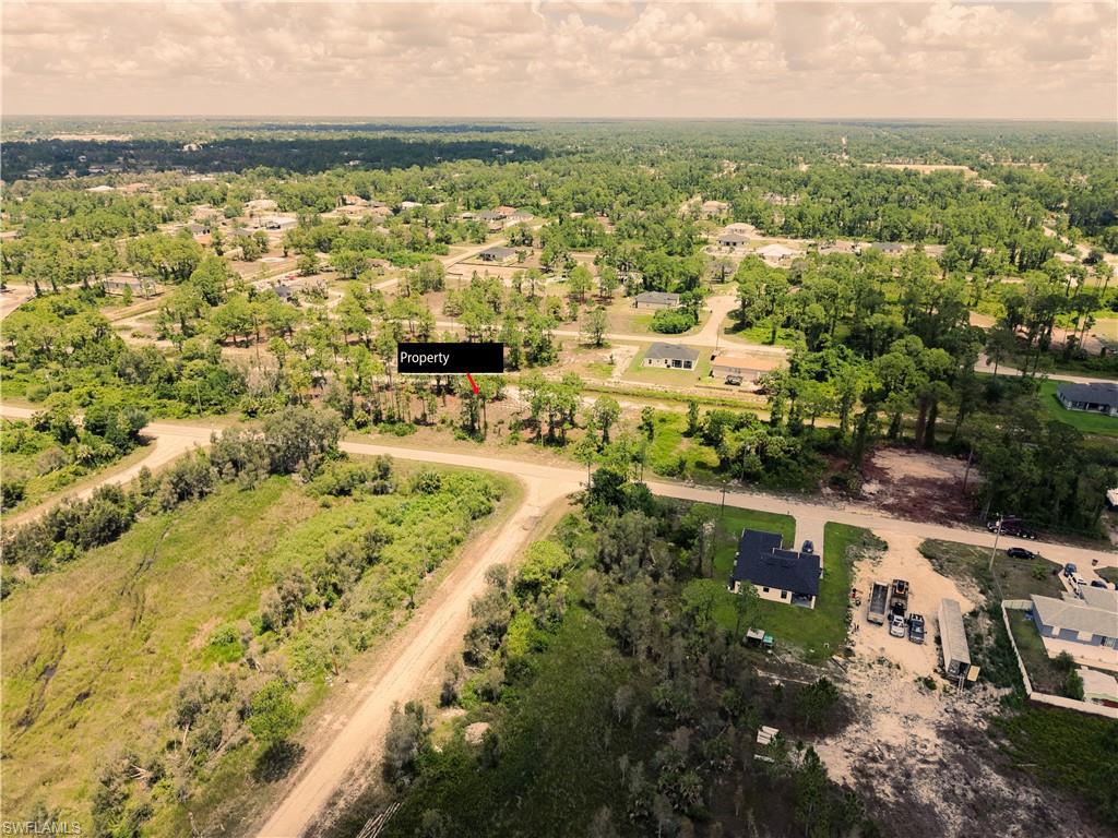 Aerial perspective showcasing a residential property surrounded by green landscaping and mature trees