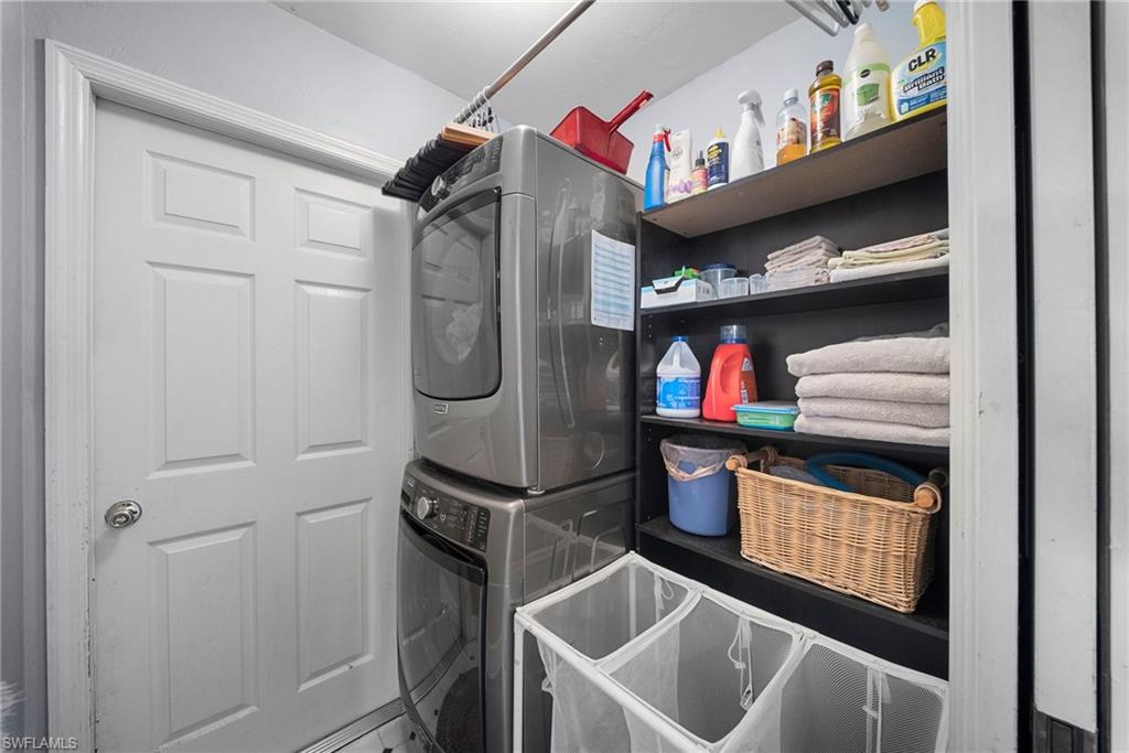 Dedicated laundry area featuring stacked appliances and built-in shelving