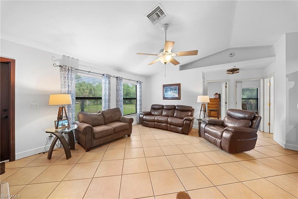 Spacious interior featuring tile flooring, vaulted ceilings, and a ceiling fan