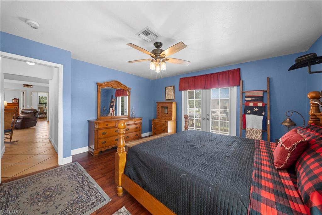 Spacious room featuring wood-finish flooring, a ceiling fan with integrated lighting, and white baseboards