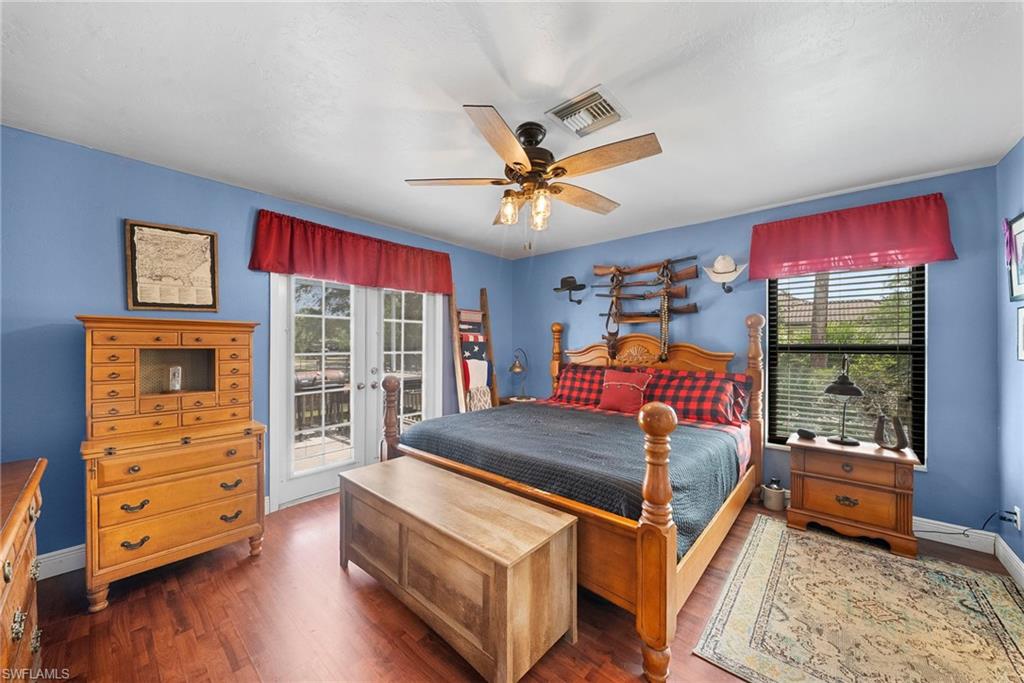 Spacious room featuring wood-finish flooring, a ceiling fan with integrated lighting, and light blue walls