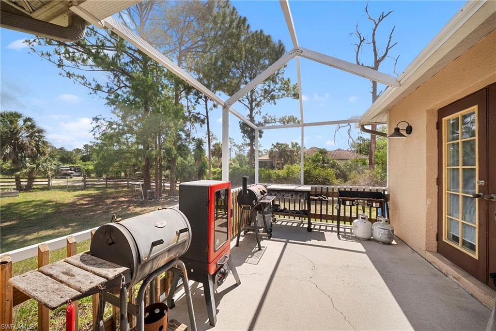 Spacious screened patio featuring a concrete floor and exterior wall-mounted lighting