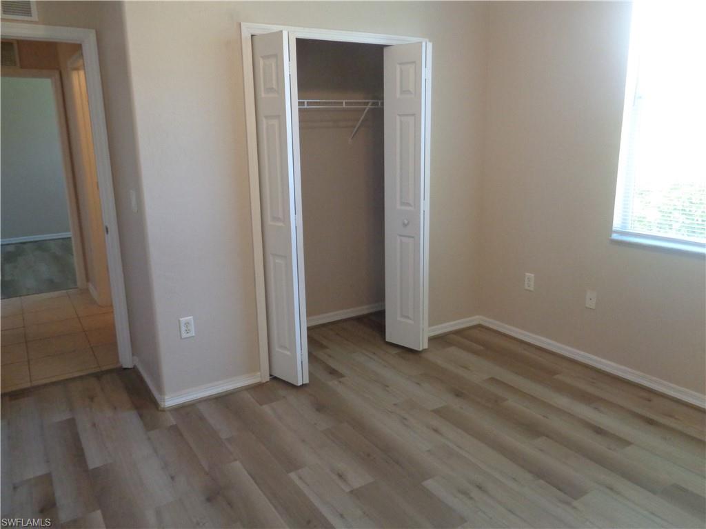 Guest Bedroom 2 with wood-like flooring and closet