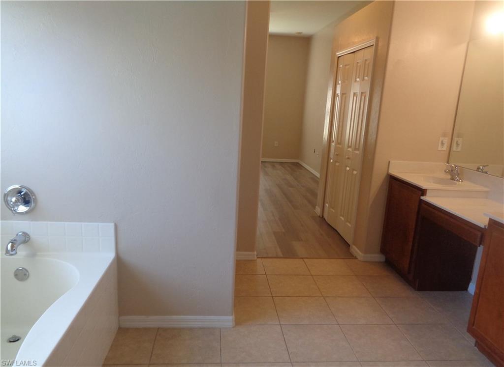 View of the Master Bedroom's bathroom with Tub, double sink vanity and tile flooring