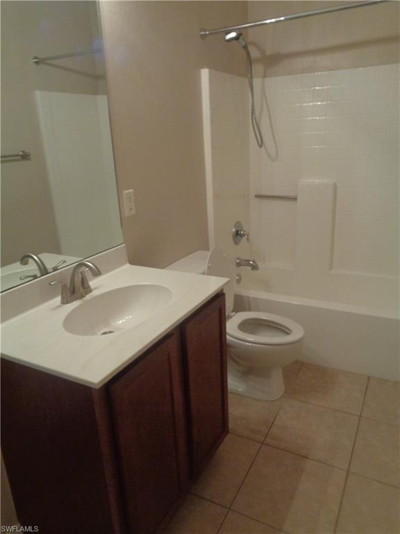 Second Bathroom with hand sink vanity, toilet, shower/tub with tile flooring