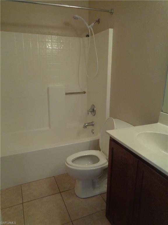 Third Bathroom with hand sink vanity, toilet, shower/tub with tile flooring