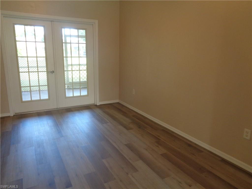 View of formal dining room with wood-like flooring and double Freench doors