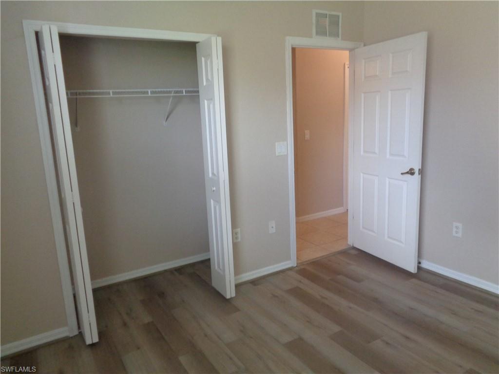 Guest Bedroom 3 with wood-like flooring and closet