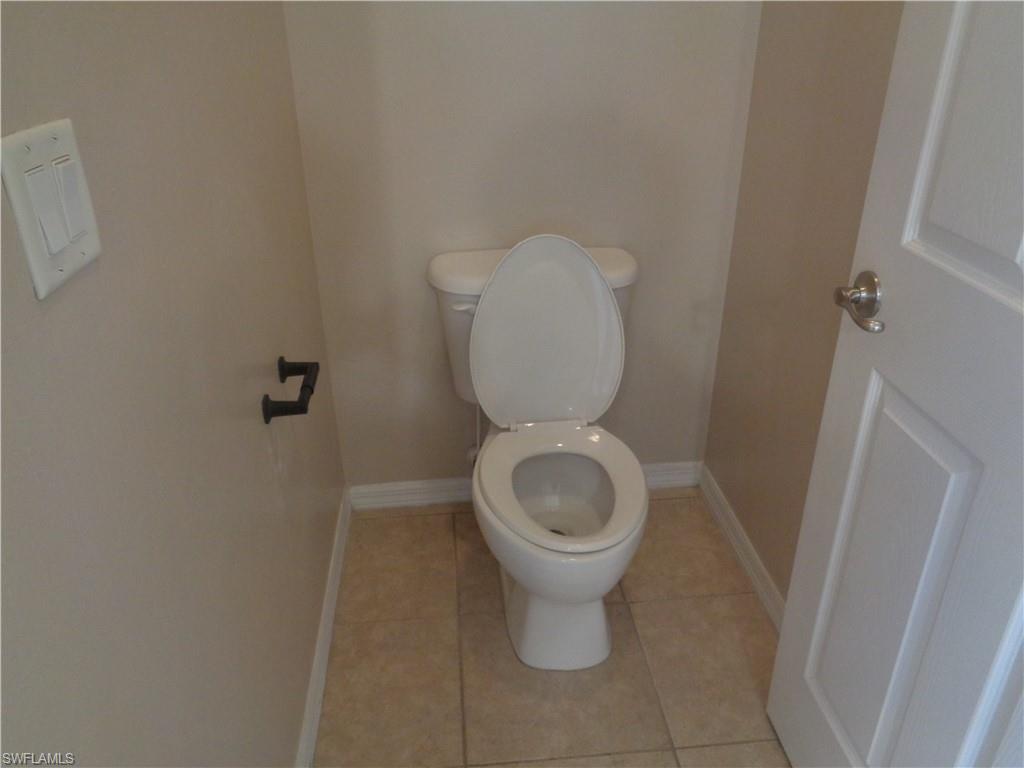 View of the Master Bedroom's bathroom with toilet enclosure and tile flooring