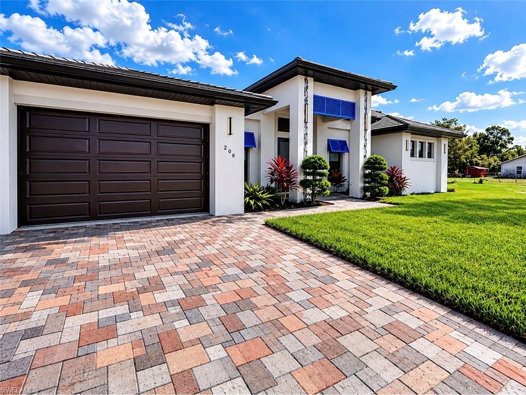Contemporary white stucco exterior with a multi-tone paver driveway