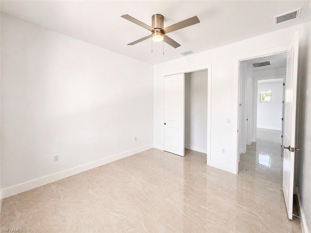 Neutral-toned tiled flooring throughout, complemented by a ceiling fan with integrated lighting