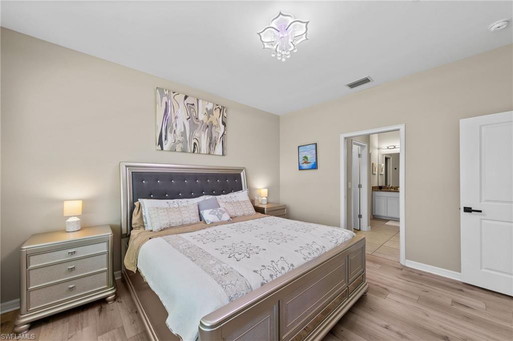 Neutral tone wall paint and wood-finish flooring define this sleeping area