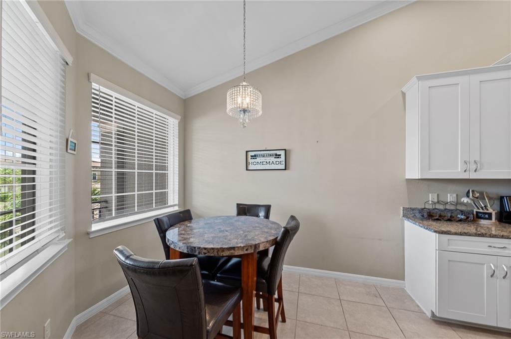 Bright dining nook featuring a vaulted ceiling and a crystal chandelier