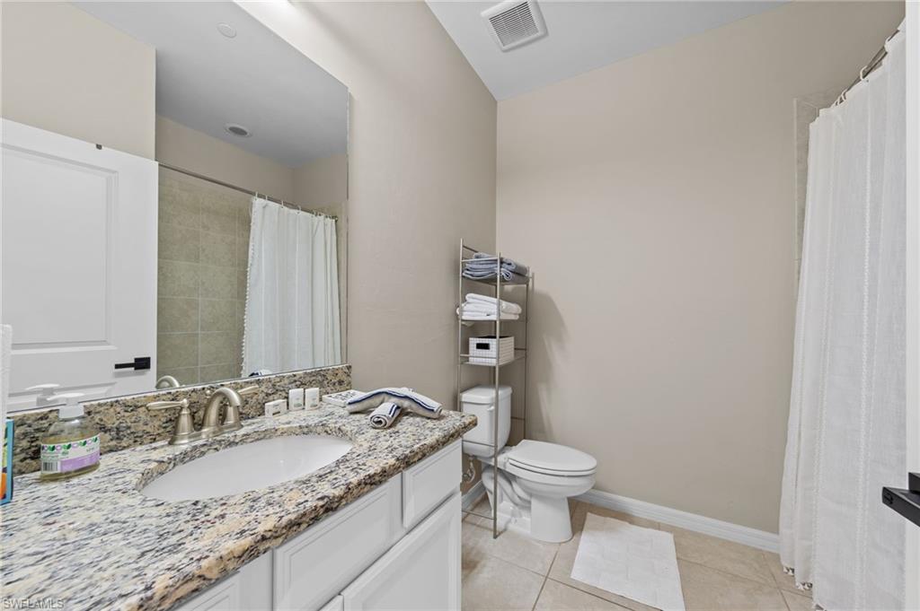 Vanity with a granite-style countertop, undermount sink, and brushed nickel faucet