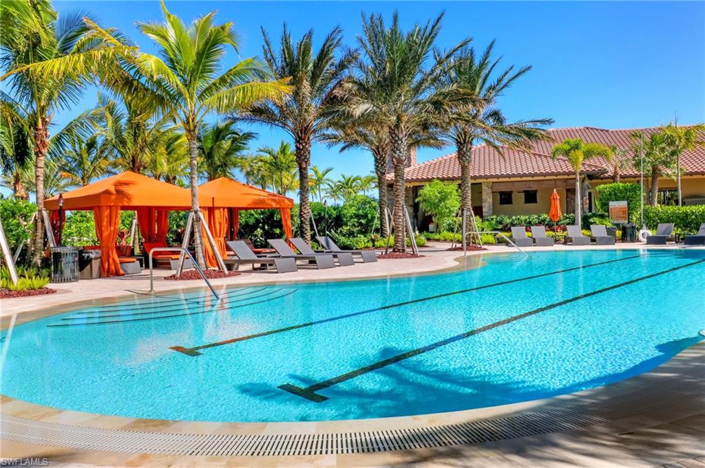 Resort-style pool area featuring multiple swimming lanes, a surrounding tiled deck, and lush tropical landscaping