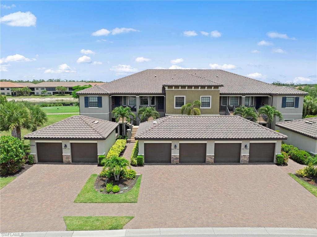 Multi-story building featuring a tile roof, stucco exterior, and multiple attached garages with paver driveways
