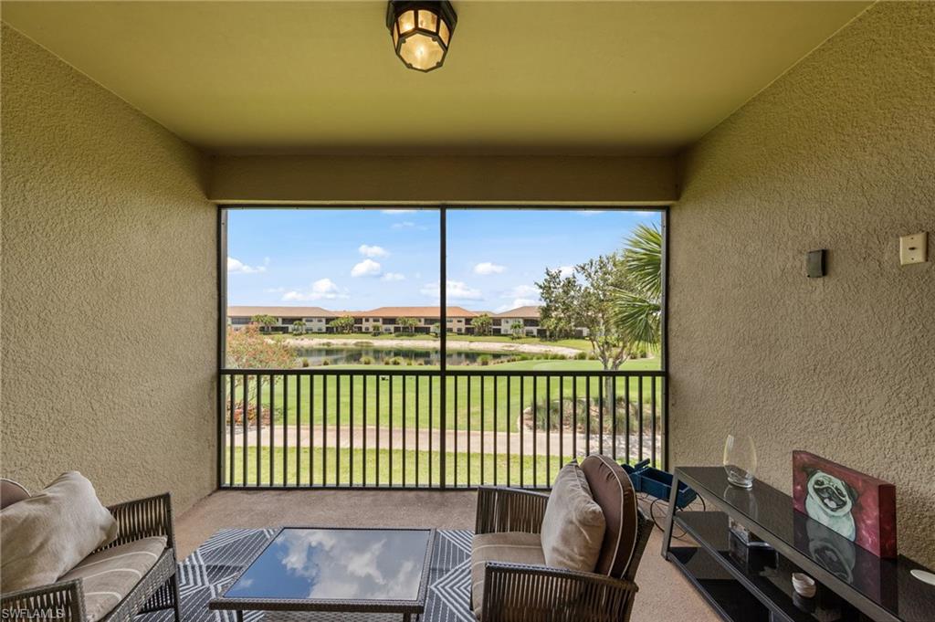Screened balcony featuring textured exterior walls and a ceiling-mounted fixture