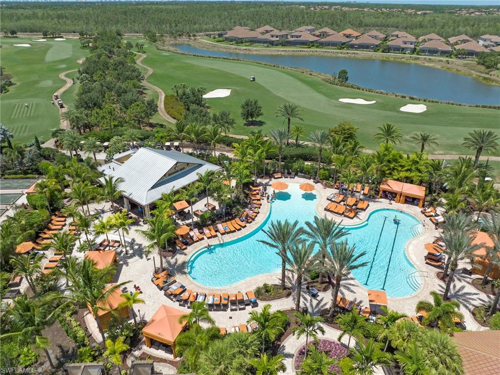 Resort-style pool complex featuring a large swimming pool with defined lap lanes, extensive lounge areas, and private cabanas