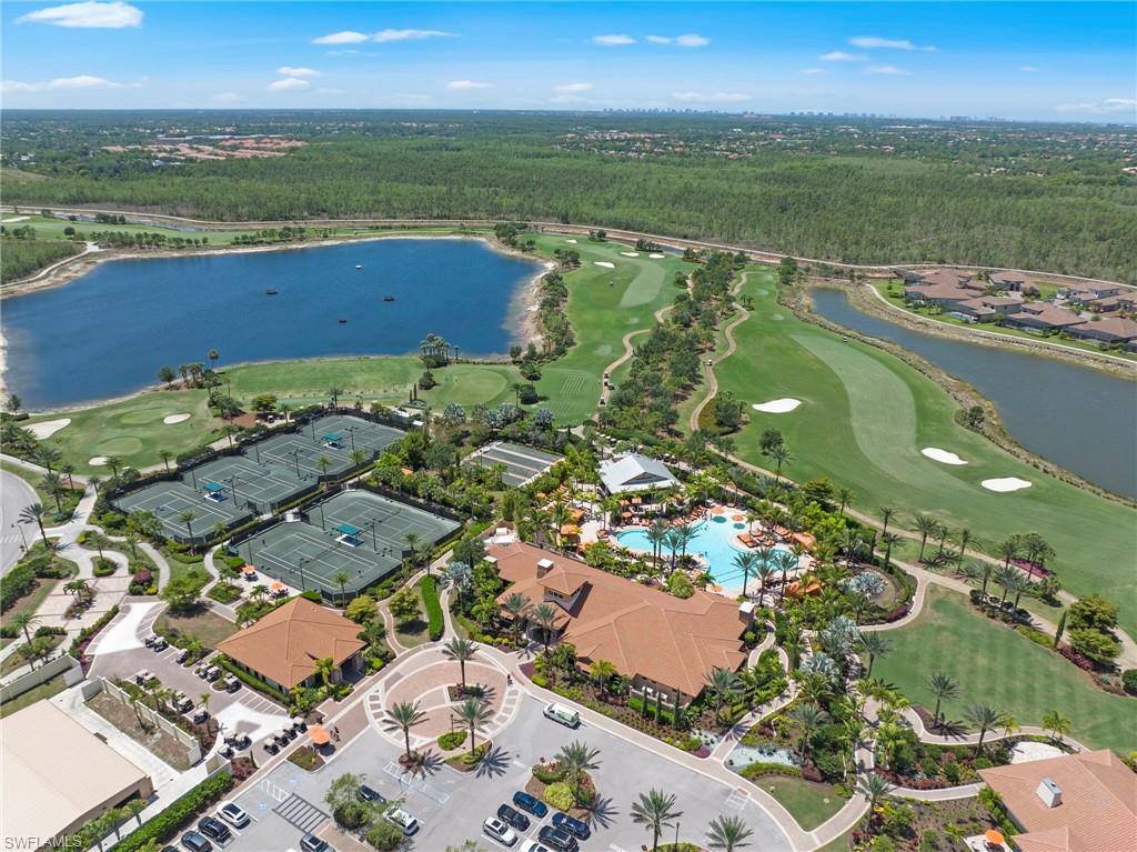Expansive aerial view showcasing a large lake, multiple tennis courts, a resort-style pool area, and a golf course with manicured greens