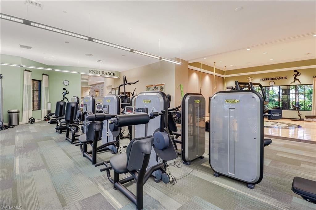 Fitness center featuring a variety of strength training equipment, patterned carpet flooring, and recessed ceiling lighting