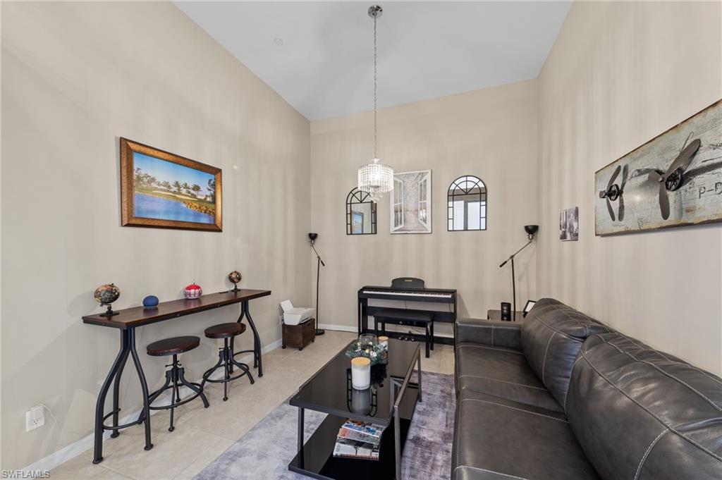Spacious interior with vaulted ceilings, neutral wall tones, and tiled flooring
