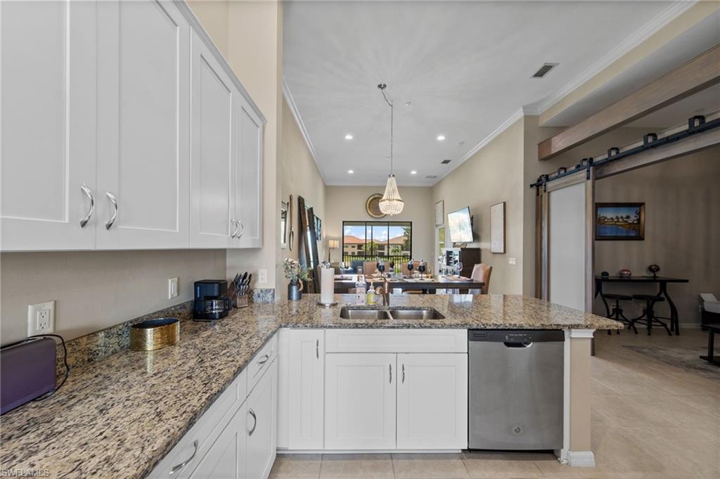 Kitchen featuring white shaker-style cabinetry, granite countertops, and a stainless steel dishwasher