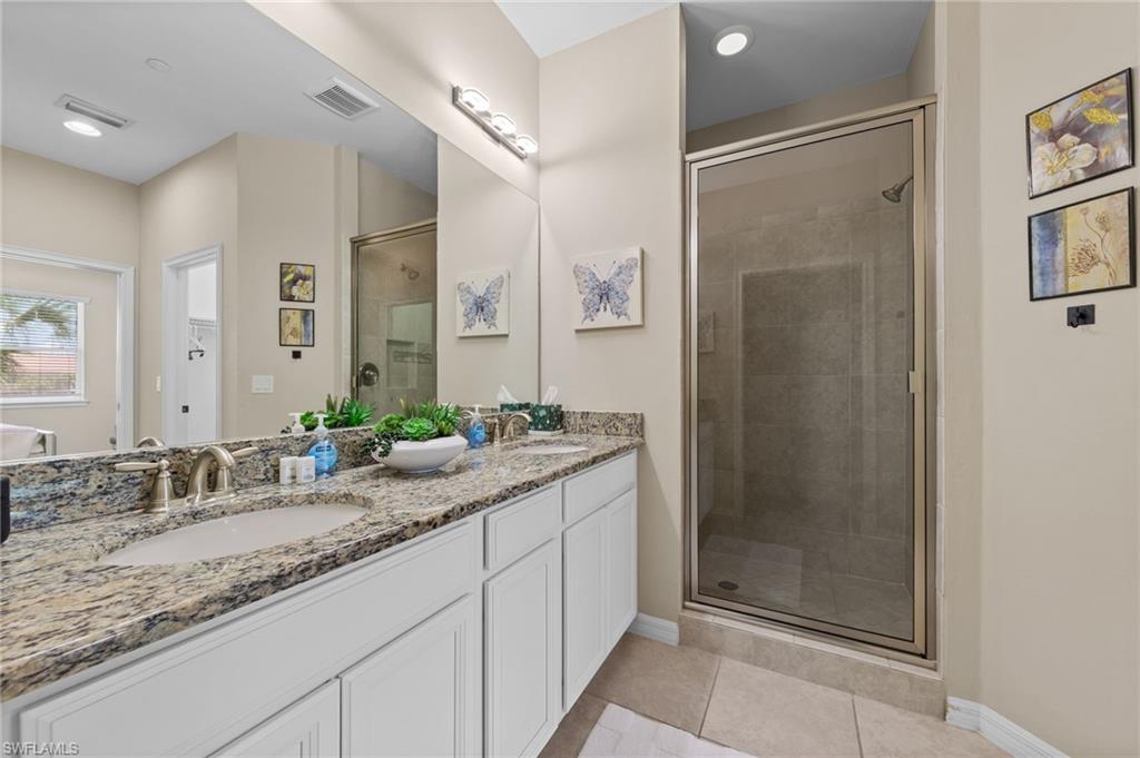 Bathroom featuring a dual vanity with granite countertops, undermount sinks, and brushed nickel faucets