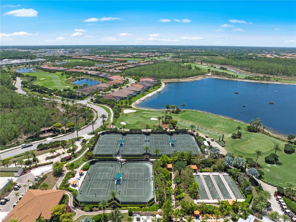 Expansive residential community featuring multiple tennis courts, bocce ball courts, a large lake, and surrounding golf course fairways