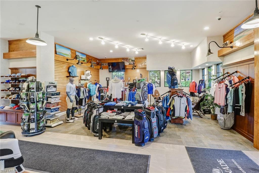 Retail space featuring tile flooring, track lighting, wood paneling, multiple display areas, and exterior windows