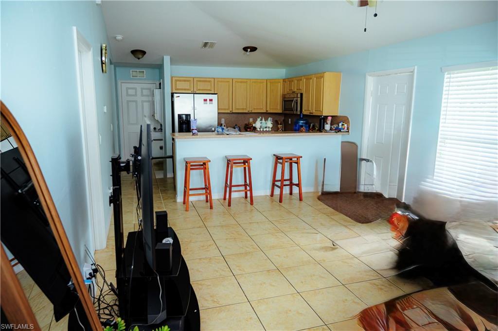 Kitchen featuring wood-finish cabinetry, stainless steel appliances, and a breakfast bar