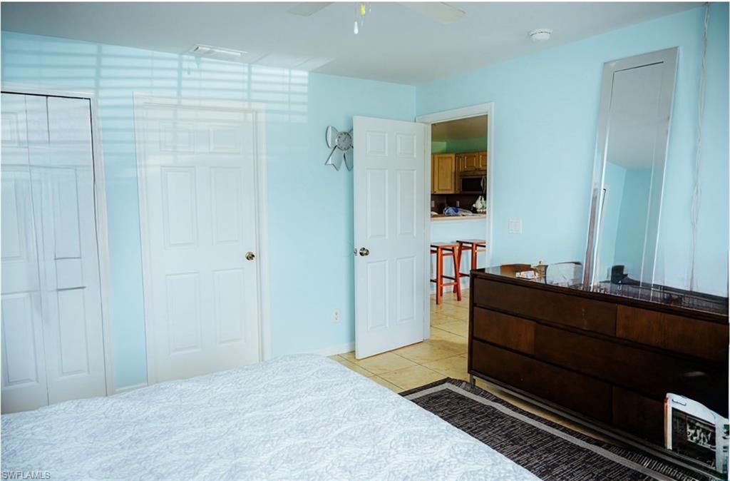Light blue interior with a paneled door, a white bi-fold closet door, and a white ceiling fan