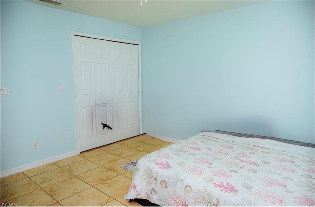 Interior space featuring light blue walls and neutral-toned tile flooring