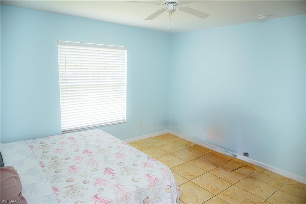 Room featuring a window with white blinds, light blue walls, and tiled flooring