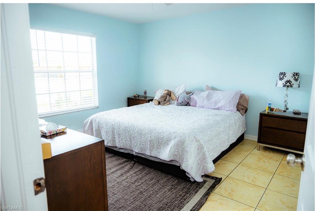 master bedroom featuring light blue walls and a window with horizontal blinds