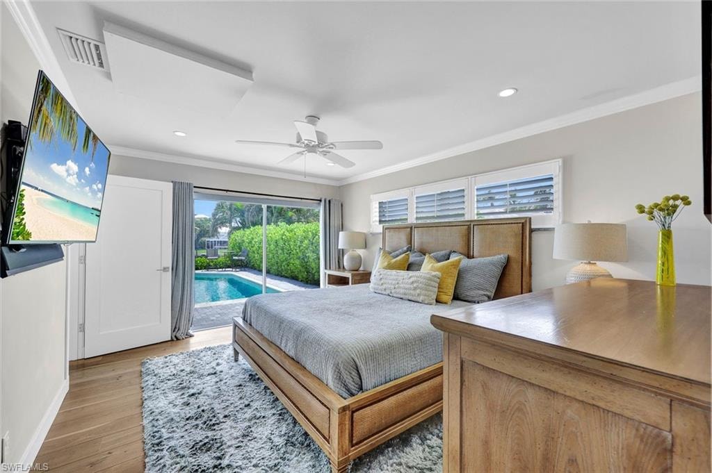 Primary Bedroom with wall of glass sliders and view of pool and landscapes