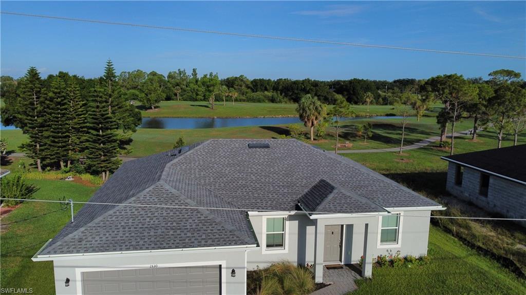 Contemporary single-story home featuring a grey shingle roof and light grey exterior siding