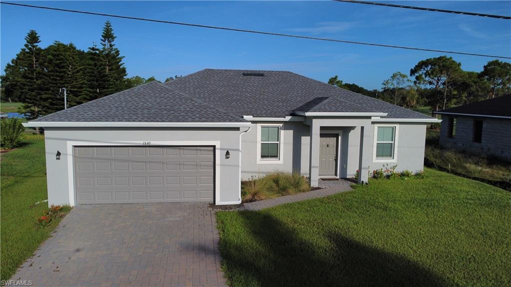 Contemporary single-story residence featuring a gray exterior, dark gray shingle roof, and an attached two-car garage with a matching gray door