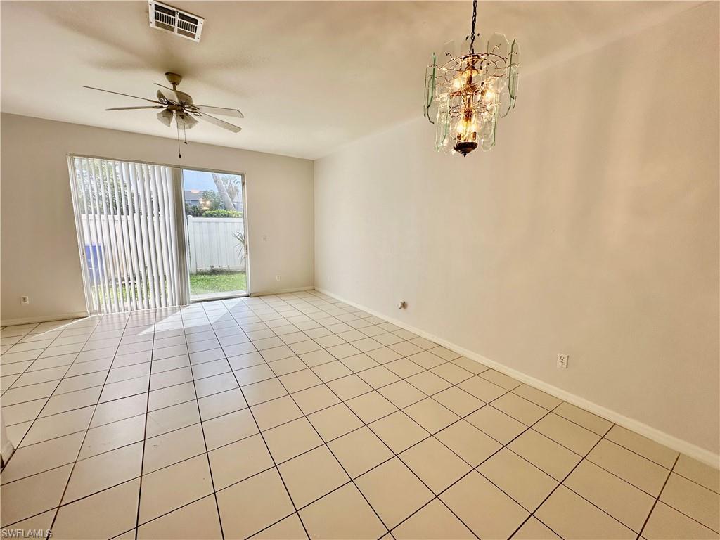View of Greatroom/Dining w Chandelier to Sliders to Backyard