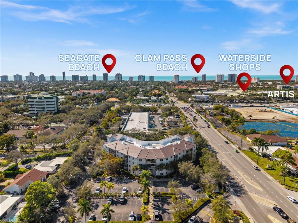 Aerial perspective showcasing a multi-story residential building with a curved facade and multiple parking areas