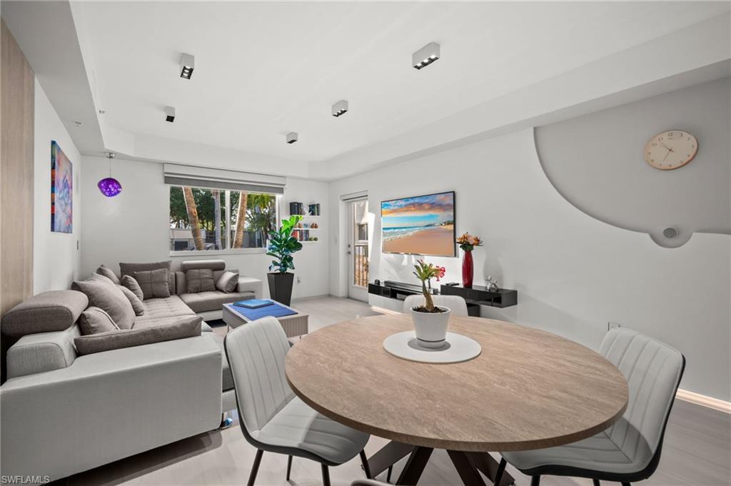 Open-concept living space featuring light-toned flooring and white walls