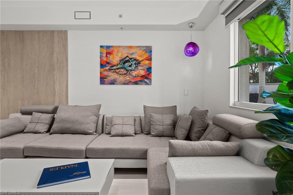 Contemporary living area featuring a neutral color palette, recessed lighting, and a large window