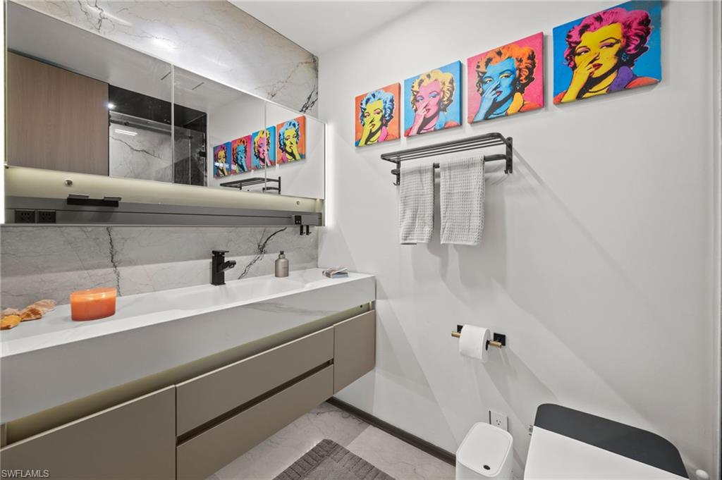 Modern bathroom vanity with integrated sink, matte black faucet, and under-cabinet lighting