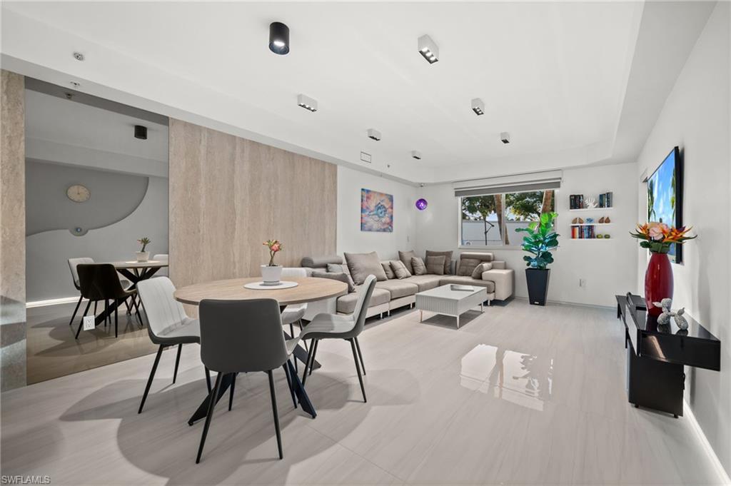 Open-concept living and dining area featuring light-toned tile flooring