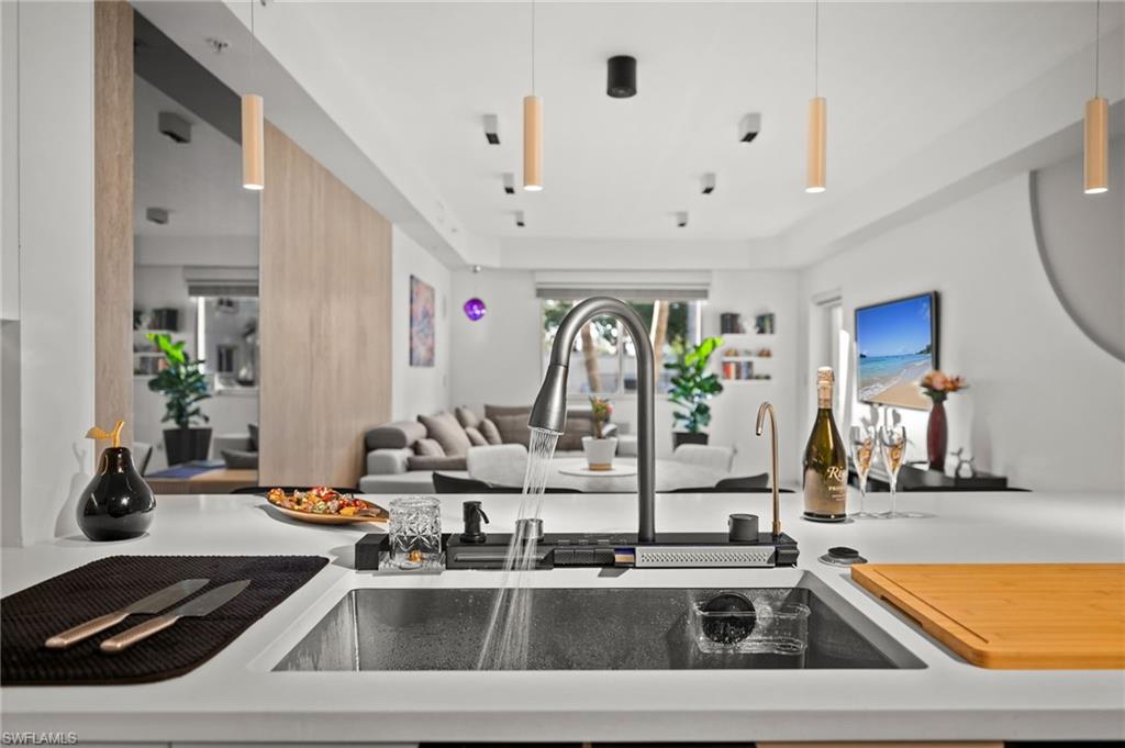 Modern kitchen featuring a large undermount sink with a pull-down faucet, a built-in water filtration system, and integrated countertop accessories
