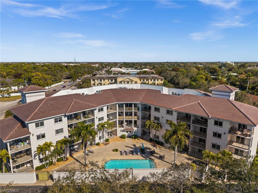 Multi-story residential building featuring private balconies, a central courtyard, and an outdoor swimming pool