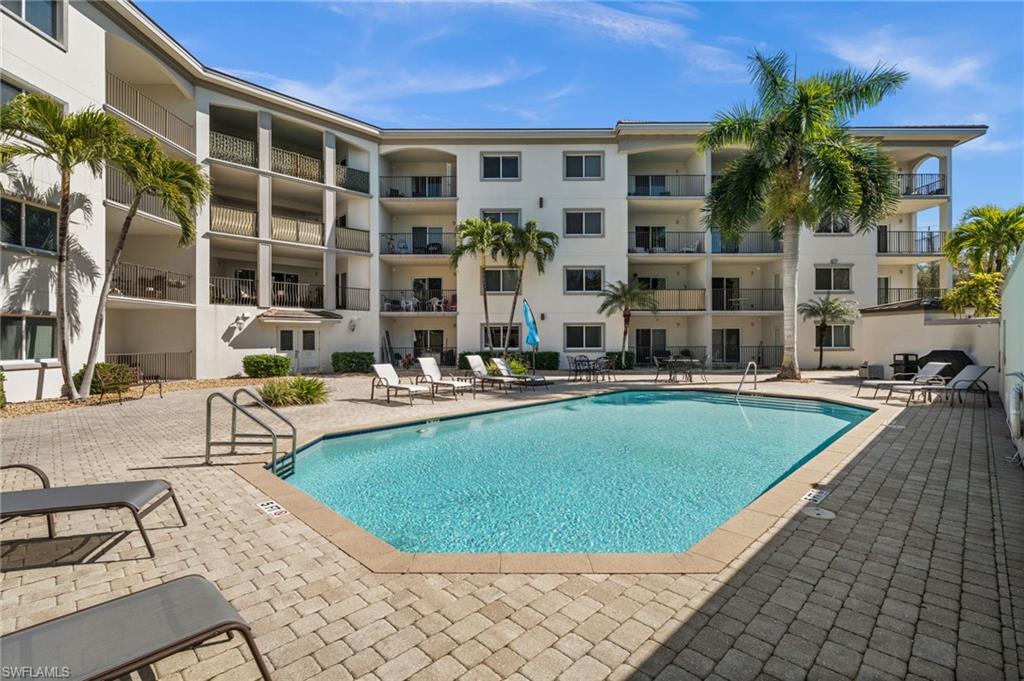 Community pool featuring a paver deck surround, integrated steps, and multiple lounge areas